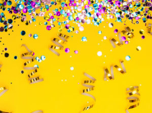 ribbons and confetti on a festive yellow background