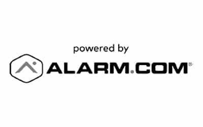 Logo with the text 'powered by ALARM.COM' in capital letters. The logo features a small geometric icon with a roof-like shape to the left of the text. The background is white.