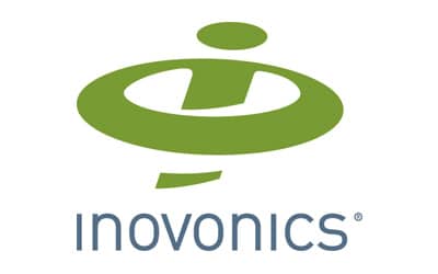 The image shows the logo for Inovonics. It includes a stylized green icon resembling an abstract lowercase 'i' within an oval shape above the company name 'inovonics' written in lowercase blue-gray text.